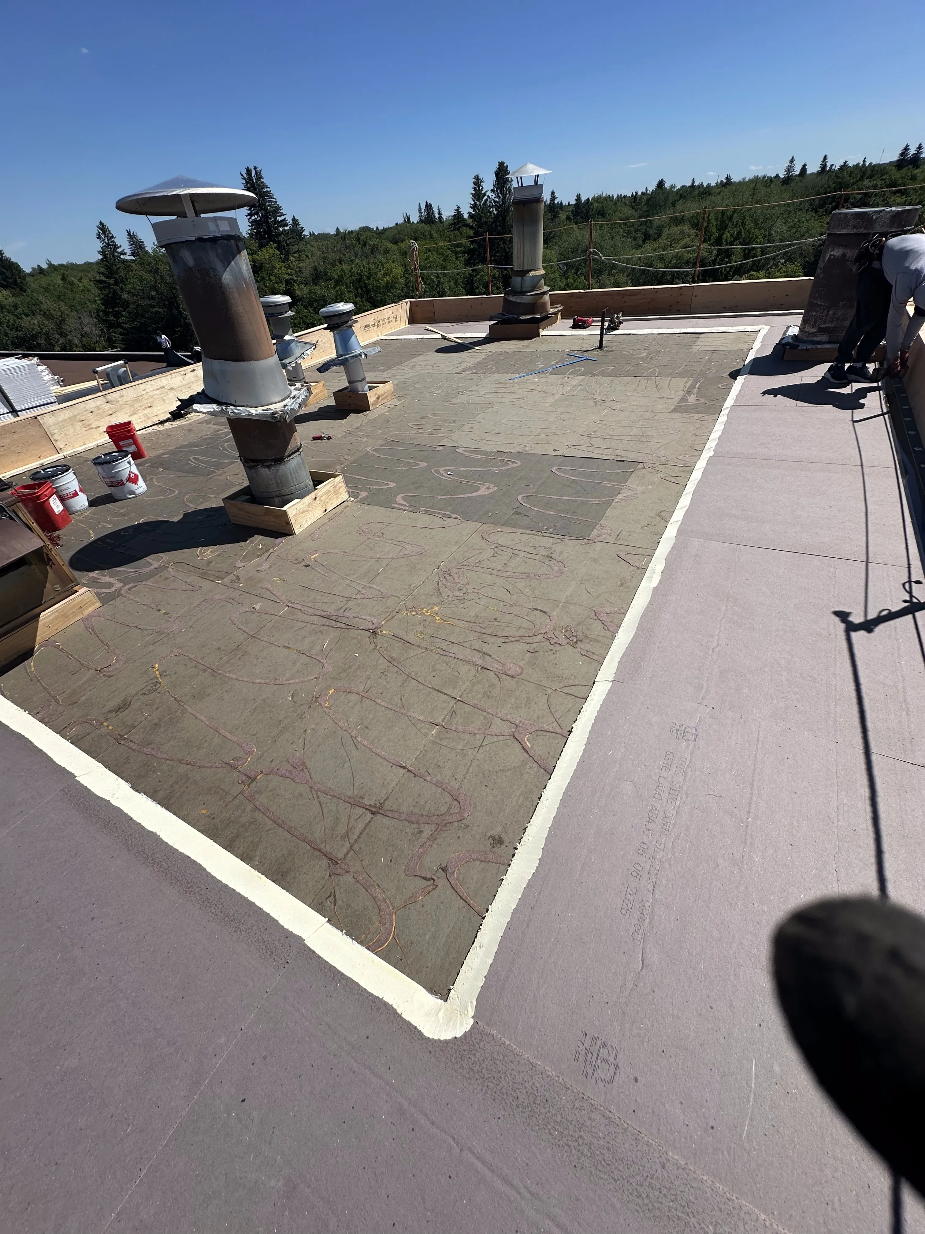 Modified bitumen base sheet with vent flashings on a Calgary commercial flat roof