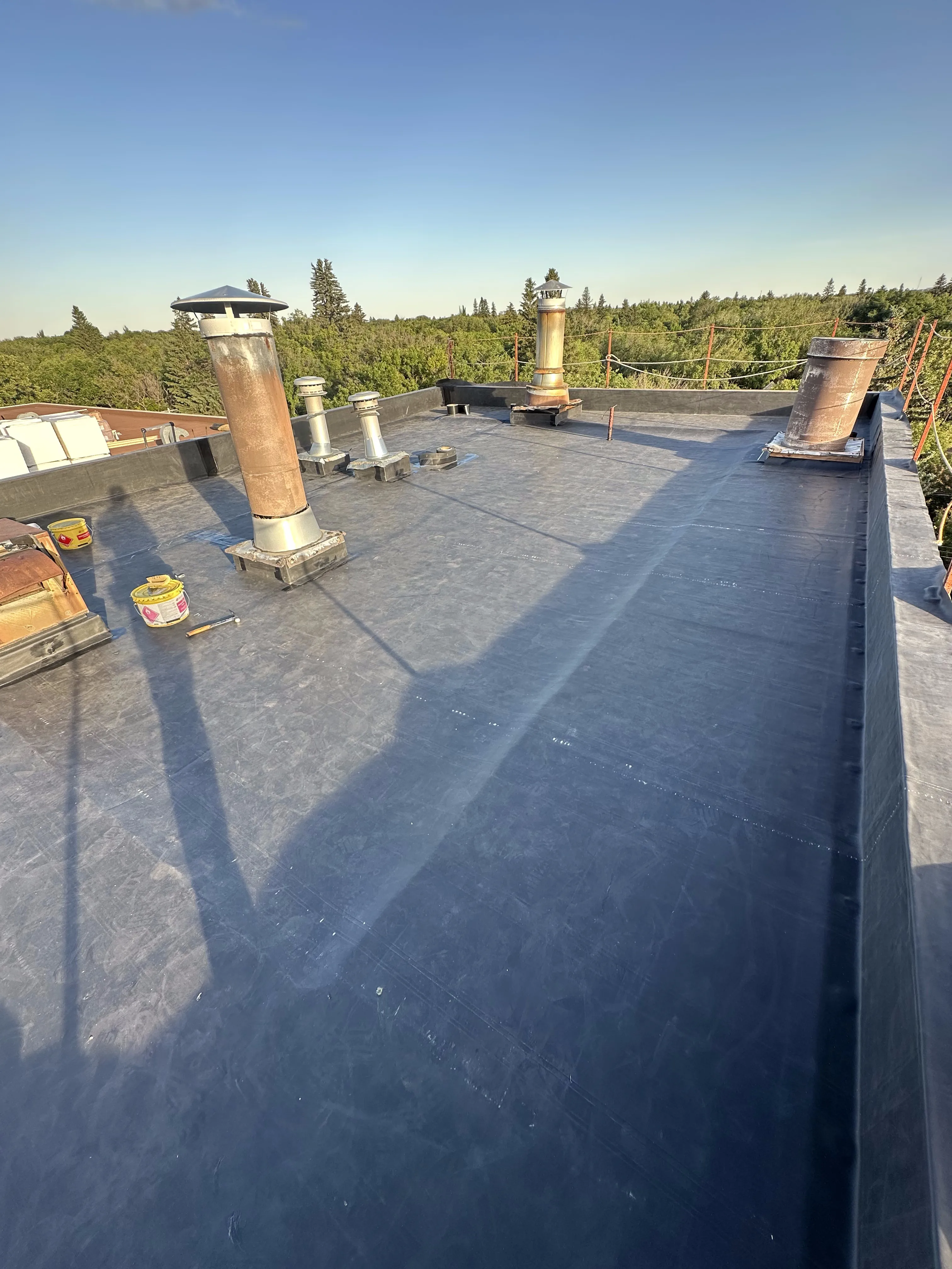 Finished EPDM flat roof with chimney and vent flashings in Calgary