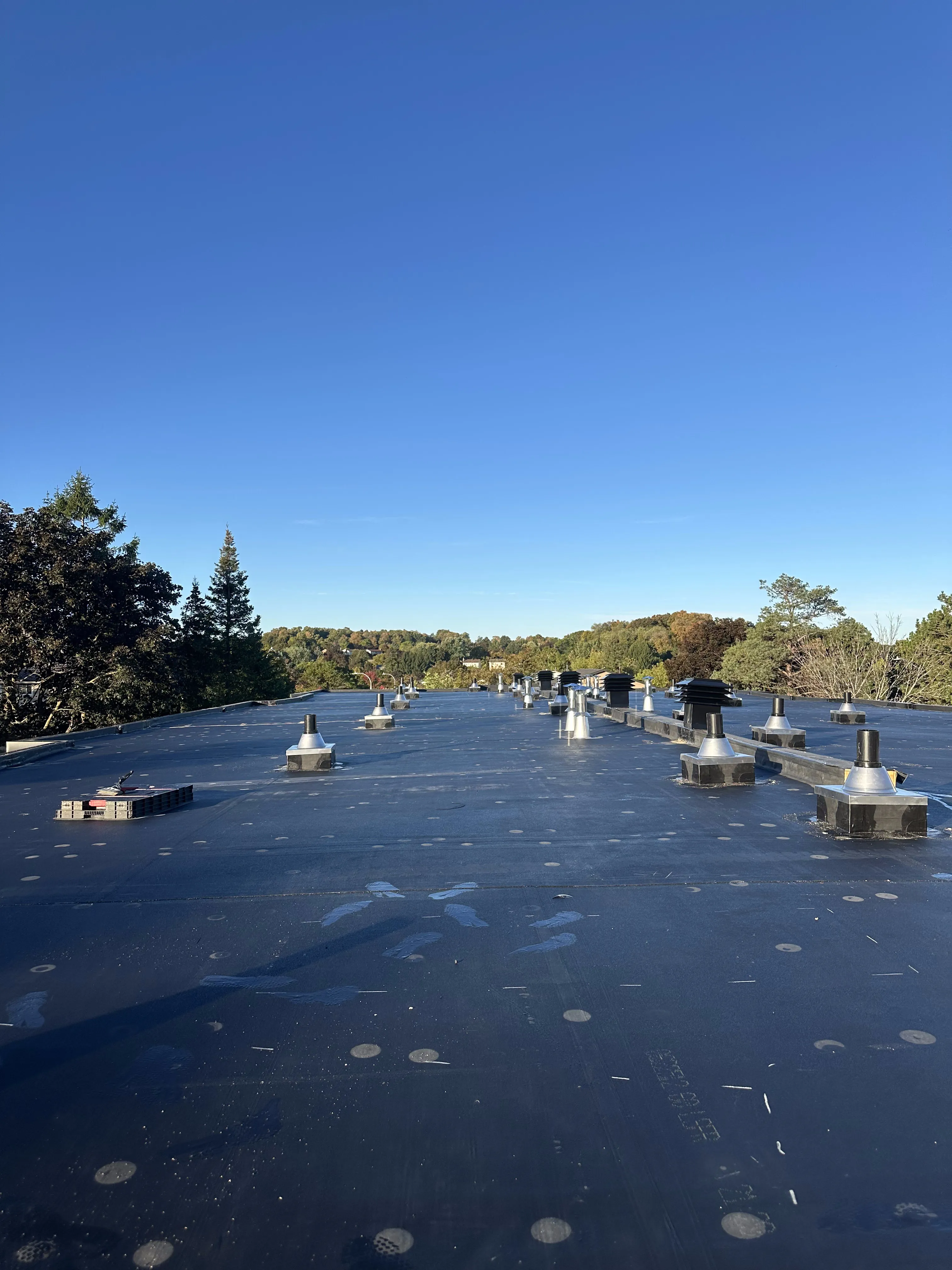 Finished EPDM flat roof with vent stacks in Calgary