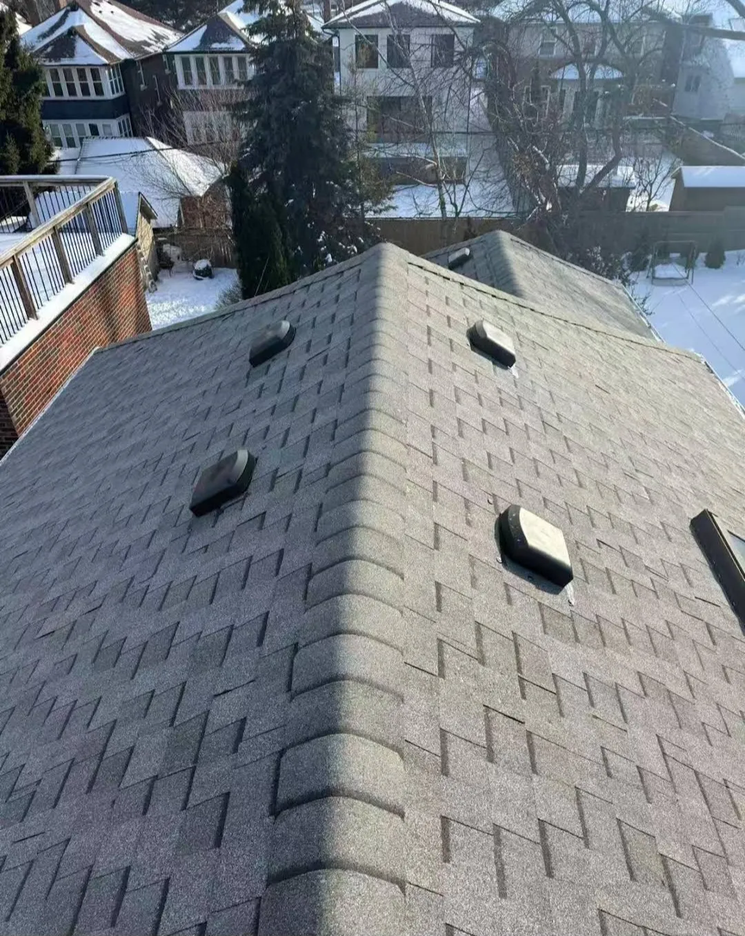 Finished grey Class 4 asphalt shingle roof with ridge caps in Calgary