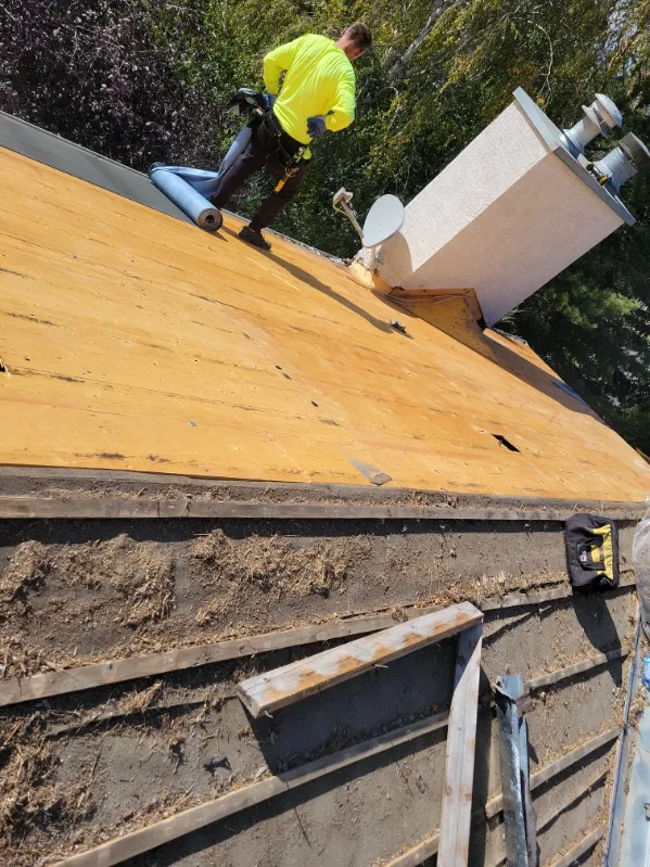 Kristian Lamthi installing synthetic roof underlayment on new plywood sheathing in Calgary