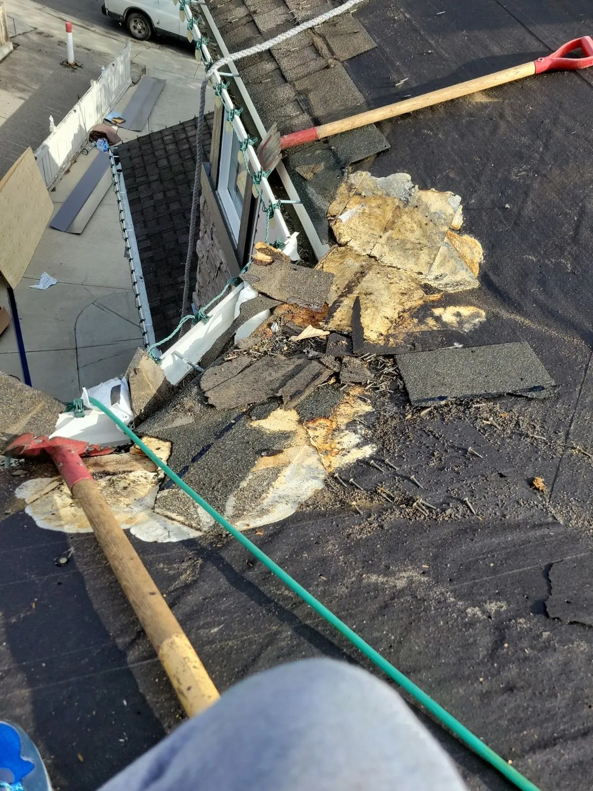 Storm-damaged Calgary roof tear-off showing water damage and torn shingles